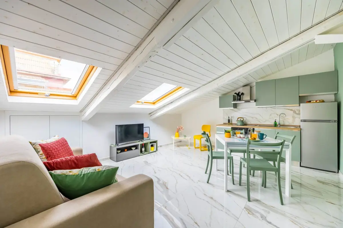 Living con divano, lucernari, TV e cucina